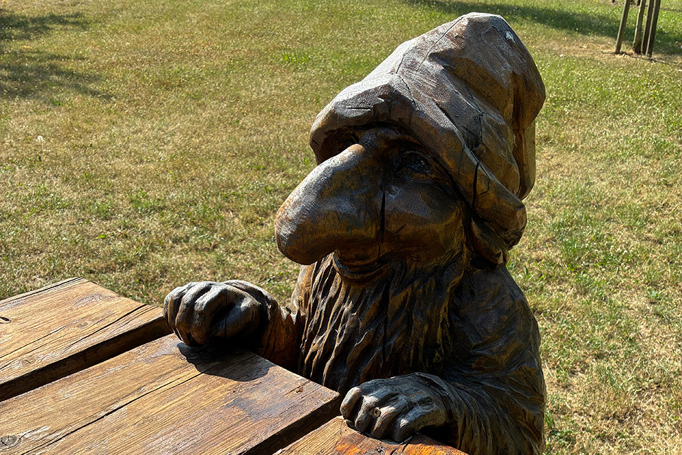 Geschnitzter Holzzwerg am Tisch